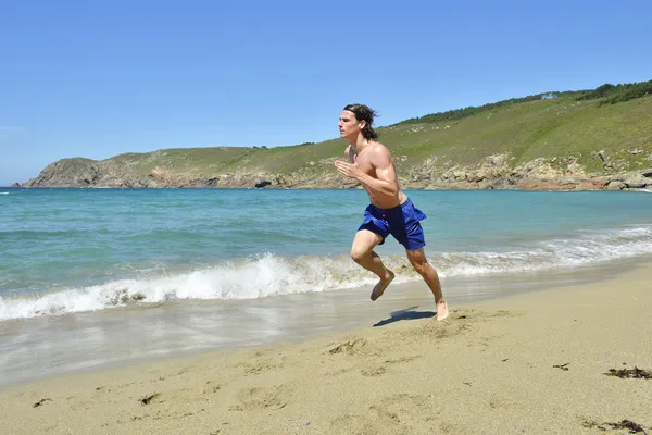 Sportsman körs på stranden — Stockfoto