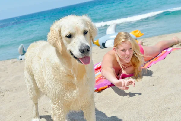 Blond girl with dog on the beach — Stock Photo, Image