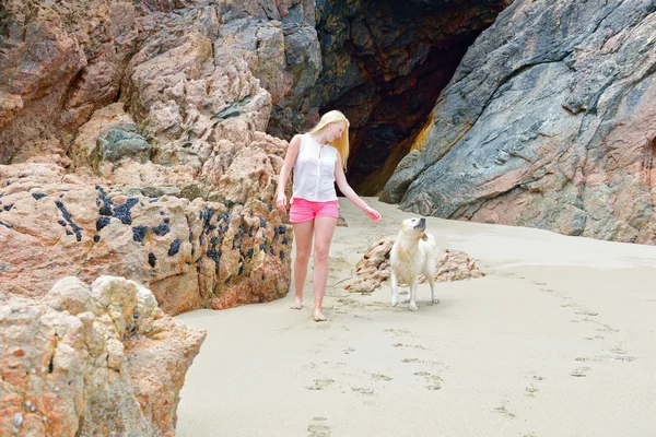 Fille blonde avec chien sur la plage — Photo