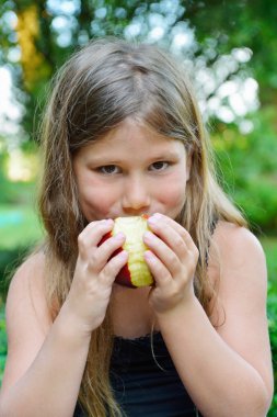 Kırmızı elma yiyen çocuk