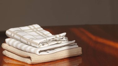 Pamuk ve keten mutfak tekstili. Peçeteler, tahta bir masanın üzerindeki havlular, yazı için yer. Yüksek kalite fotoğraf