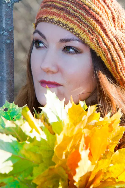 Thoughtful face of autumn woman with maple leaves in nature fall — Stock Photo, Image