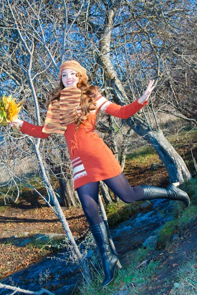 Beautiful caucasian girl with long curly hair with leaves dancing outdoors — Stock Photo, Image