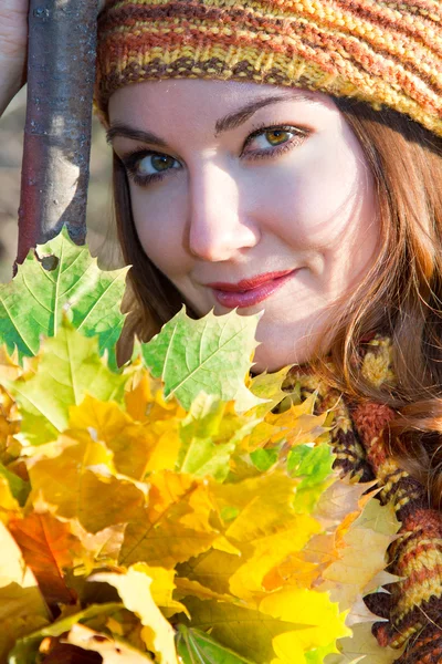 Close up portrait of autumn woman in knitted beret with maple leaves on nat — Stock Photo, Image