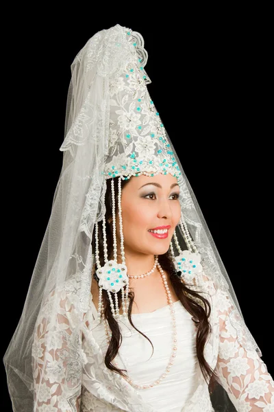 Красивая женщина в казахском национальном свадебном белом платье на черной спине — стоковое фото