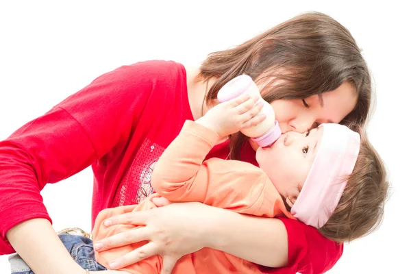 Mère nourrit son bébé avec un biberon avec des préparations pour nourrissons dans la maison. Le c — Photo