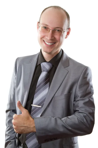 El hombre exitoso en un traje de negocios gris muestra un positivo en un backgro blanco —  Fotos de Stock