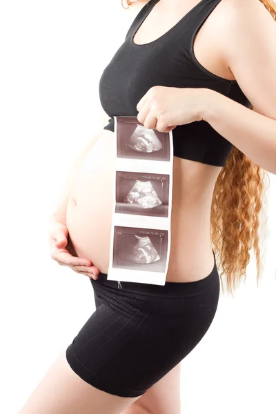 Pregnant woman s belly with the ultrasound images in the hands of a white b — Stock Photo, Image