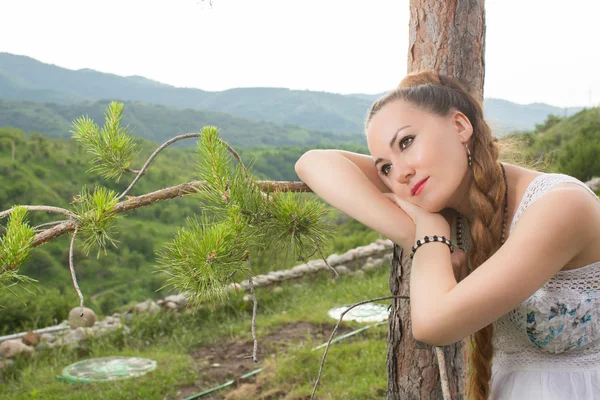 Retrato de una hermosa mujer joven cerca del árbol en el parque de verano —  Fotos de Stock