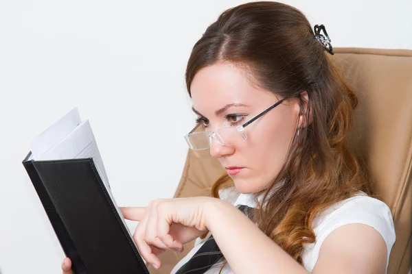 Grave manager donna leggere le note in un taccuino a una scrivania in ufficio — Foto Stock