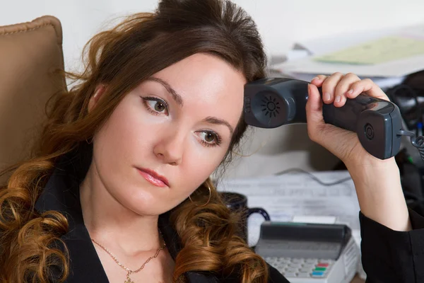 Glückliches Büroangestelltenmädchen am Festnetztelefon, das Gespräch hört — Stockfoto