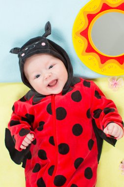 güzel bebek kız, yeşil zemin üzerine ladybug Kostüm giymiş. Çocukluk ve tatil kavramı