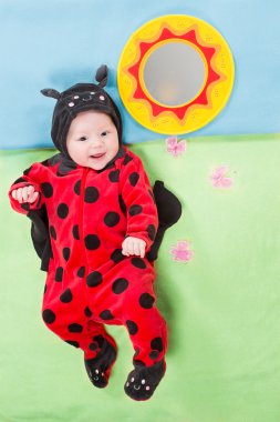 güzel bebek kız, yeşil zemin üzerine ladybug Kostüm giymiş. Çocukluk ve tatil kavramı