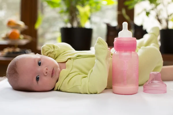 Neugeborenes Mädchen mit einer Flasche Milch. das Konzept der Ernährung und Kindererziehung — Stockfoto