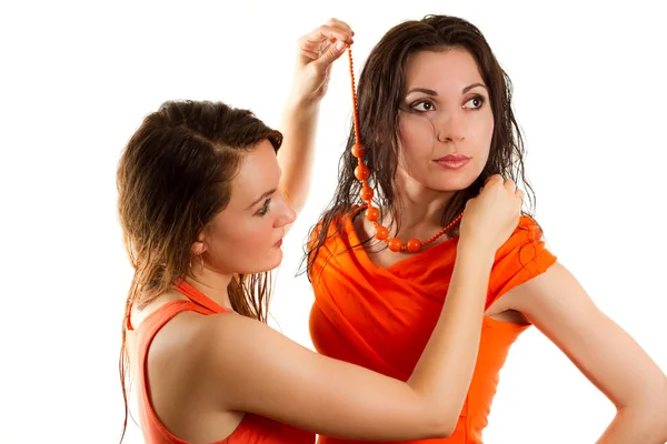 Two beautiful women try on the beads around his neck on a white background — Stock Photo, Image