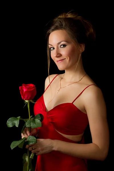 Retrato de uma jovem mulher bonita com rosa vermelha no fundo preto — Fotografia de Stock