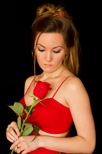 Retrato de uma jovem mulher bonita com rosa vermelha no fundo preto — Fotografia de Stock