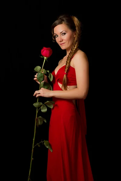 Πορτρέτο του μια νεαρή όμορφη γυναίκα με το κόκκινο τριαντάφυλλο σε μαύρο φόντο — Φωτογραφία Αρχείου