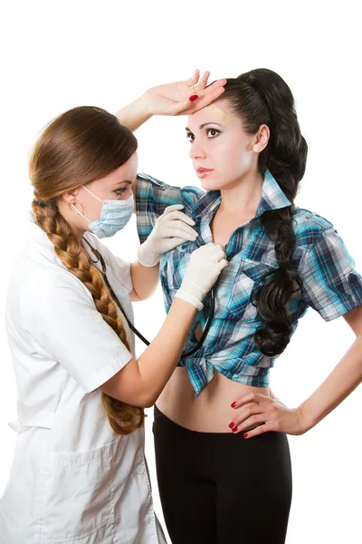 Ärztin oder Krankenschwester, die einem jungen Patienten vor weißem Hintergrund eine Untersuchung mit Stethoskop gibt — Stockfoto