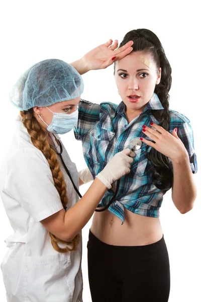 Médico ou enfermeiro fêmea a fazer check-up com estetoscópio para doentes jovens sobre fundo branco — Fotografia de Stock