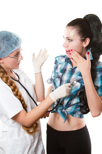 Kvinnliga läkare eller sjuksköterska ger checkup med stetoskop till ung patient över vit bakgrund — Stockfoto