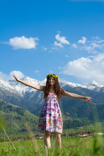 Vrouw in kransen van paardebloemen op de natuur — Stockfoto