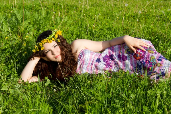 Young beautiful girl laying on the flowers dandelions, outdoor portrait, summer fun concept — Stock Photo, Image