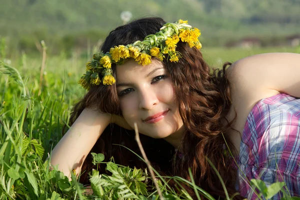 Hermosa womanl en la corona se encuentra en la hierba, concepto divertido de verano —  Fotos de Stock