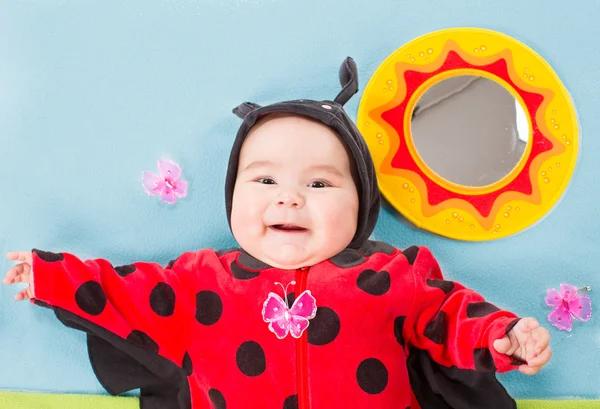 Jolie petite fille, habillée en costume de coccinelle sur fond vert Le concept de l'enfance et des vacances — Photo