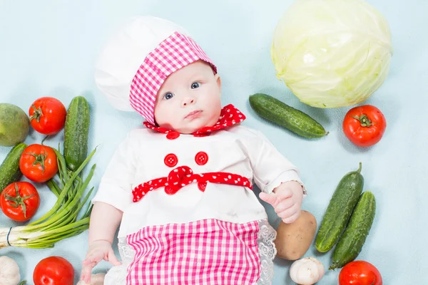 Kız bebek sebze ile chef şapka giyiyor. bir çocuk için sağlıklı gıda kavramı kullan — Stok fotoğraf