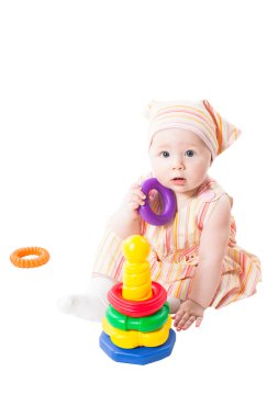 Baby girl playing with toy pyramid build from rings isolated on white background.Toy for children and toddlers to joyfully learn mechanical skills and colors.
