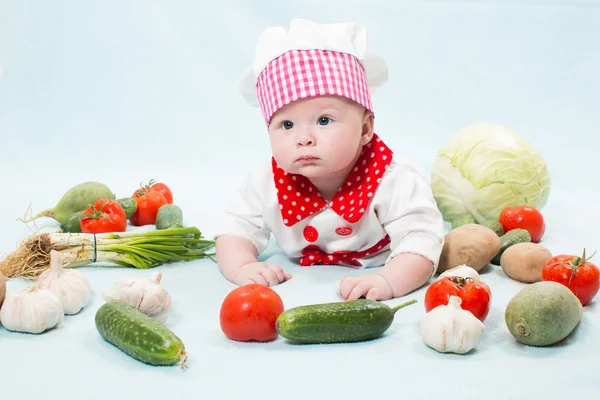 Kız bebek sebze ile chef şapka giyiyor. bir çocuk için sağlıklı gıda kavramı kullan — Stok fotoğraf