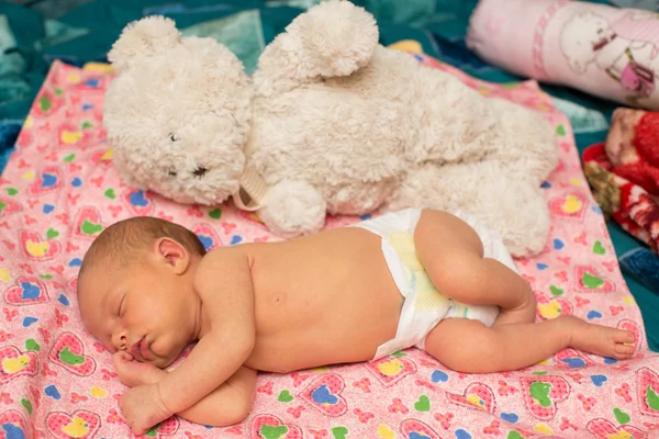 Neugeborenes Mädchen schläft mit Spielzeug auf dem Bett. Nutzen Sie es für ein Kind, Elternschaft oder Liebeskonzept — Stockfoto