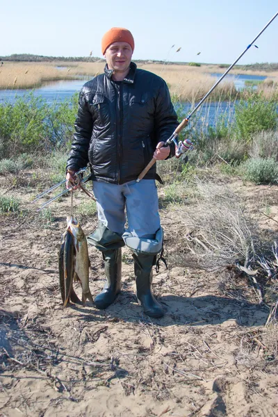 Heureux pêcheur chanceux tenant une grosse carpe sur la rivière. Au petit matin sur la pêche — Photo