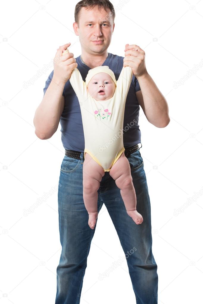 Father does exercises dynamic gymnastics with child, on isolated. The concept of sports, baby yoga and healthy lifestyle.