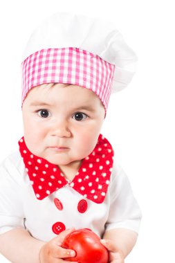 kız bebek domates ile chef şapka giyiyor. bir çocuk için sağlıklı gıda kavramı kullan