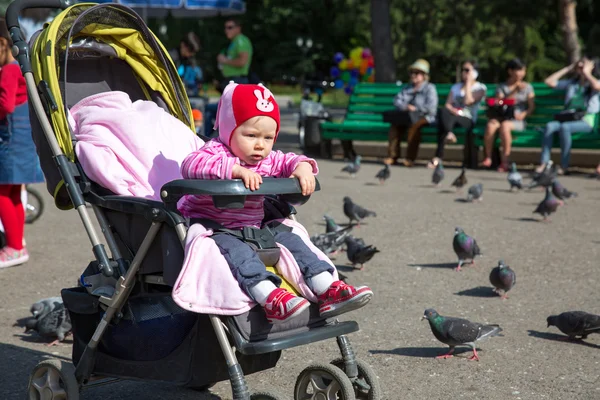 Dítě dívka si hraje s holubice v ulici města — Stock fotografie