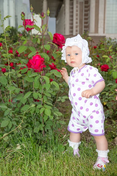 Uśmiechający się ładny mały dziecko dziewczynka kwiat róży w parku — Zdjęcie stockowe