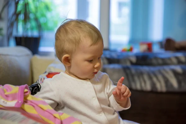 Söt liten barn flicka ser på hans dreglar hemma — Stockfoto