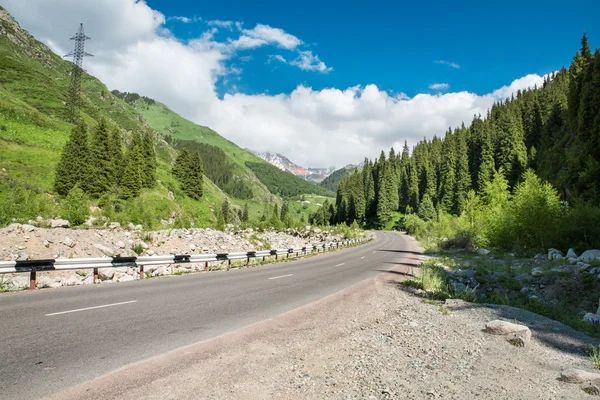 Carretera en Big Almaty Lake, montañas verdes naturales y cielo azul en Almaty, Kazajstán, Asia en verano —  Fotos de Stock