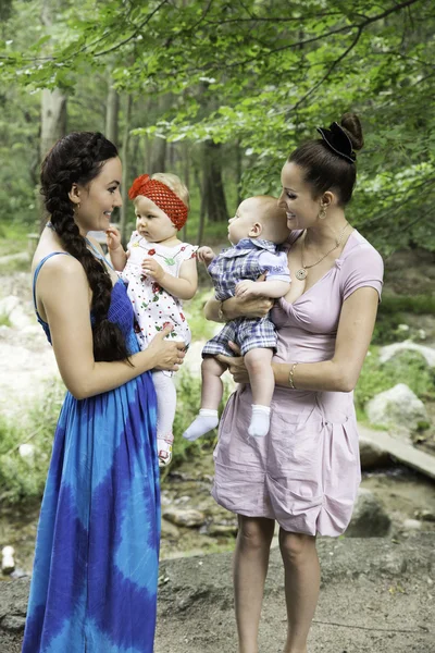 Två glada vackra mödrar och barn kramas och skrattar. begreppet barndom och familj. — Stockfoto