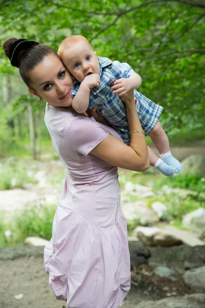 Feliz mamá y el niño abrazando y riendo. El concepto de la infancia y la familia. Hermosa madre y su hijo al aire libre —  Fotos de Stock