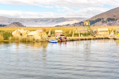 kimliği belirsiz kadın geleneksel elbiseler: puno, peru uros Island'da turistlere hoş geldiniz.