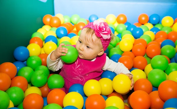 Fröhliches Kindermädchen in buntem Ball auf Spielplatz — Stockfoto