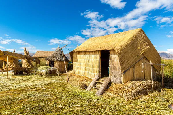 Kryte strzechą domu na pływające wyspy na jeziorze titicaca puno, peru, Ameryka Południowa. gęste korzenia, że rośliny khili przeplatają postaci naturalnej warstwy około jednego do dwóch metrów grubości obsługujących wyspy — Zdjęcie stockowe