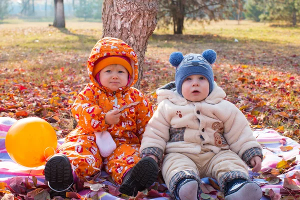 Kind jongen en meisje spelen met bladeren — Stockfoto