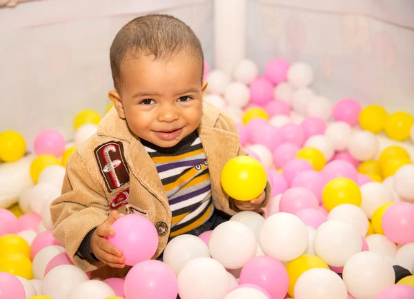 Happy black boy in colored balls — Stock Photo, Image