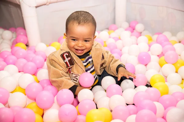 Niño negro en bolas de colores —  Fotos de Stock