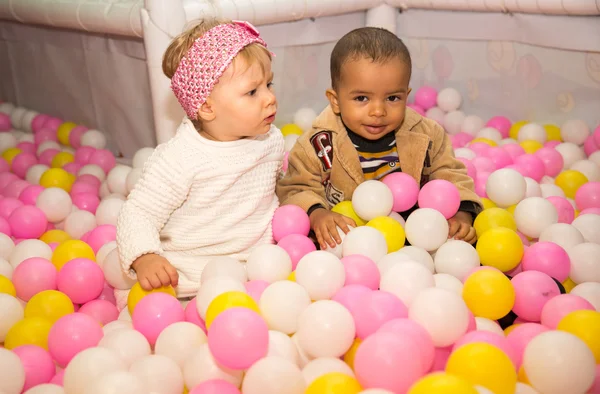 Happy children in colored balls — Stock Photo, Image