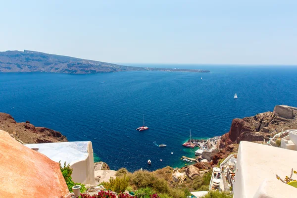 Vista da cidade de Fira - Ilha de Santorini, Creta, Grécia. Escadarias de concreto branco que levam até a bela baía com céu azul claro e mar — Fotografia de Stock